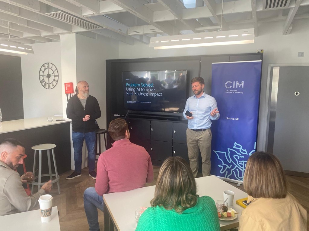 Marketers look at a screen as Ewan Anderson introduces speaker John Hughes at the CIM Social event